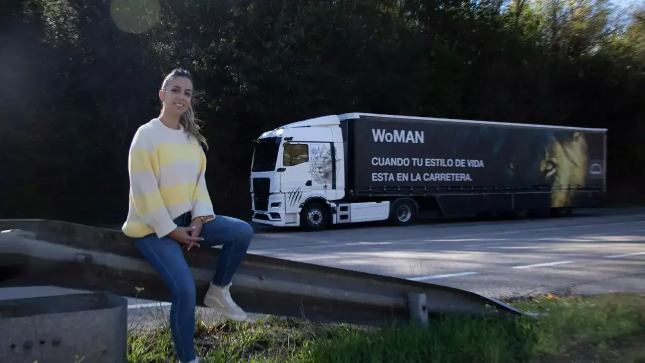 Mujer junto a un camión con el lema "WoMAN". ¿Esta permitido conducir un camión con el permiso B?