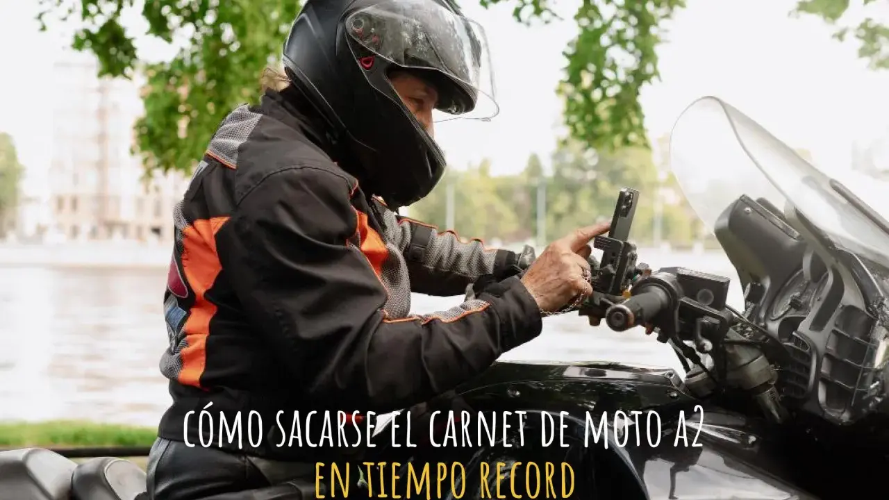 Persona con casco y chaqueta de moto ajustando su móvil en el manillar. ¿Cuánto se tarda en sacar el carnet de moto A2?