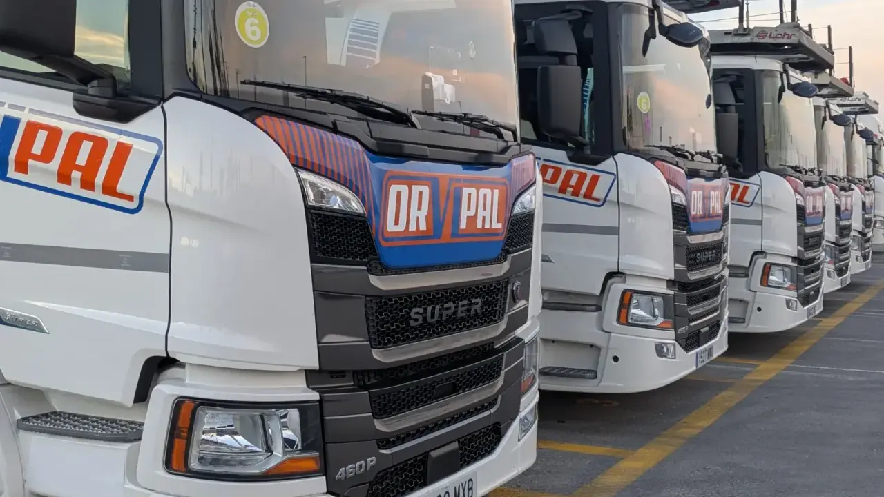 Fila de camiones Scania Super blancos, listos para la carretera.