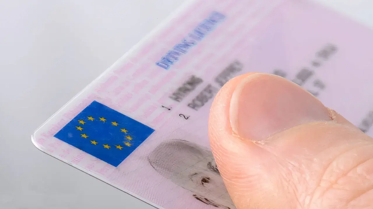 Pulgar sobre un carnet de conducir B2 con el logo de la UE.