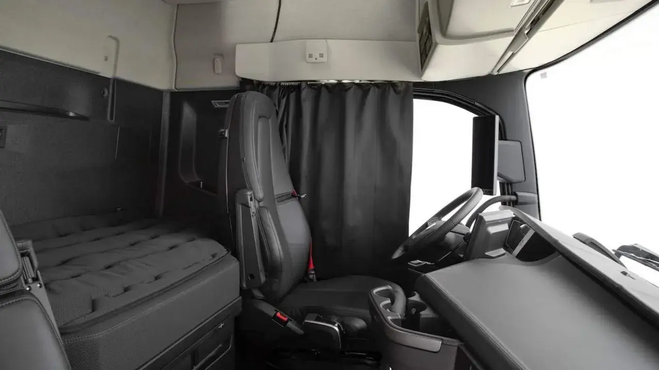 Interior de un camión Volvo FH XXL. Asiento del conductor, cama y volante.
