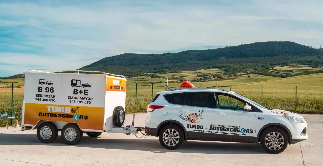 Coche blanco de autoescuela Turbo con remolque. Preparados para obtener el carnet B+E.