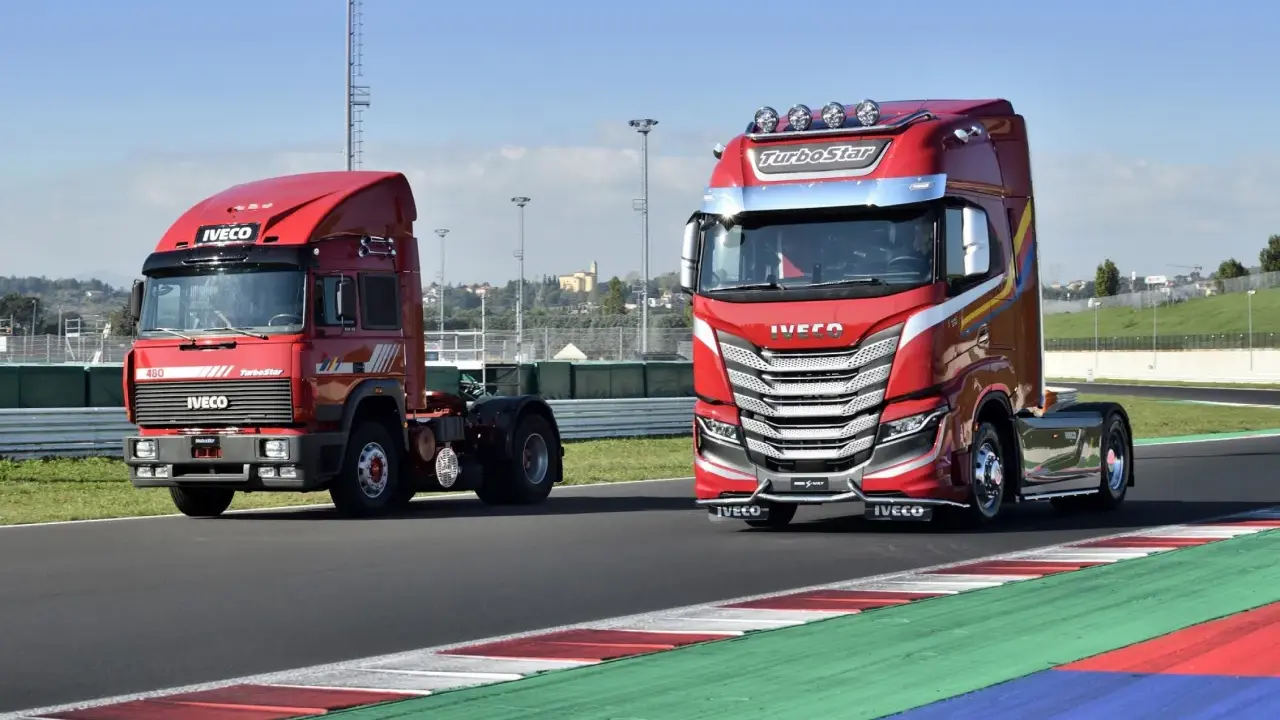 Dos camiones Iveco rojos, uno antiguo y otro moderno, en una pista de carreras.