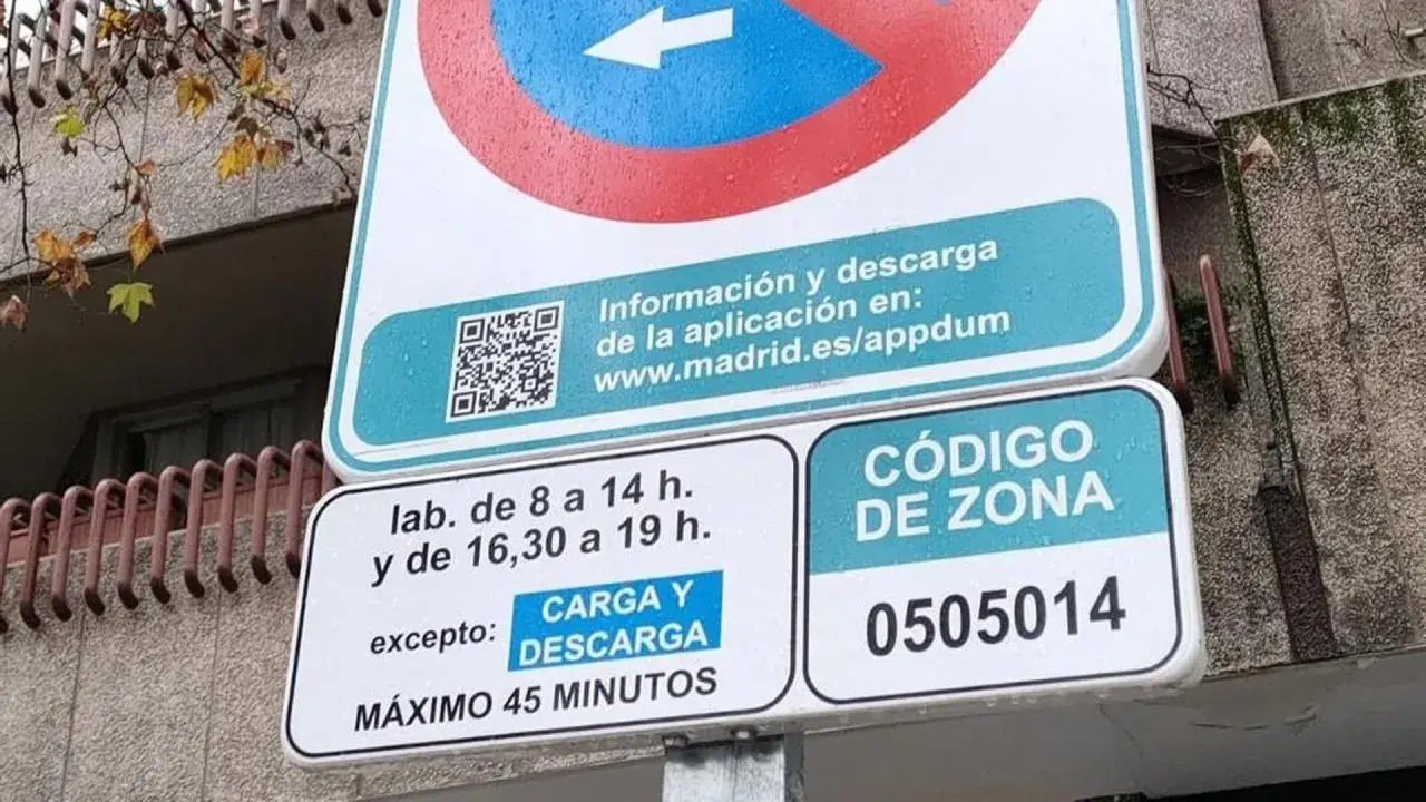 Señal de tráfico de carga y descarga con horarios y código de zona.