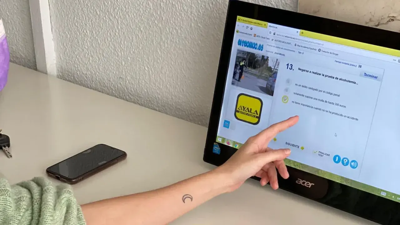 Persona estudiando para el examen de moto A2. La pantalla muestra una pregunta sobre la prueba de alcoholemia, indicando que el examen tiene 38 preguntas.