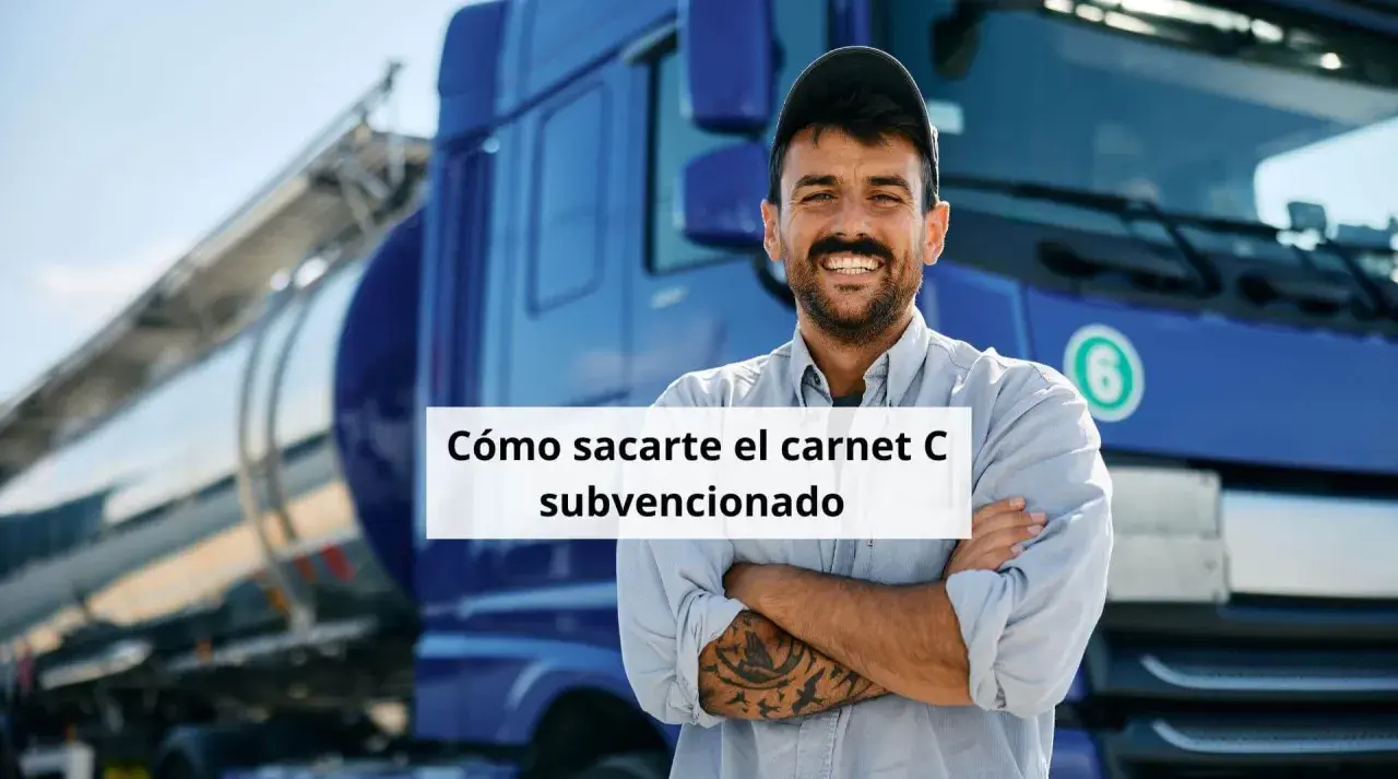 Hombre sonriente con tatuajes, frente a un camión cisterna azul. Aprende cómo obtener tu carnet de camión gratis para desempleados.
