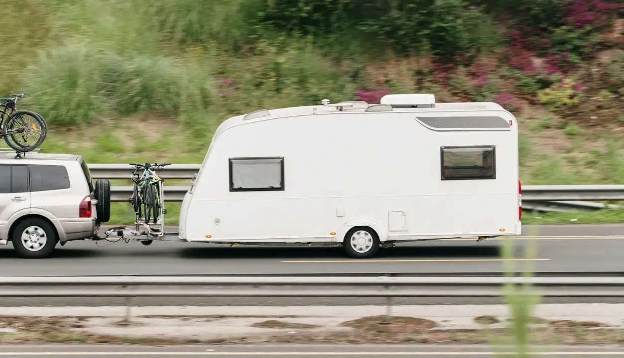 Vehículo todoterreno con remolque caravana y bicicletas, listo para viajar con el permiso de circulación b.