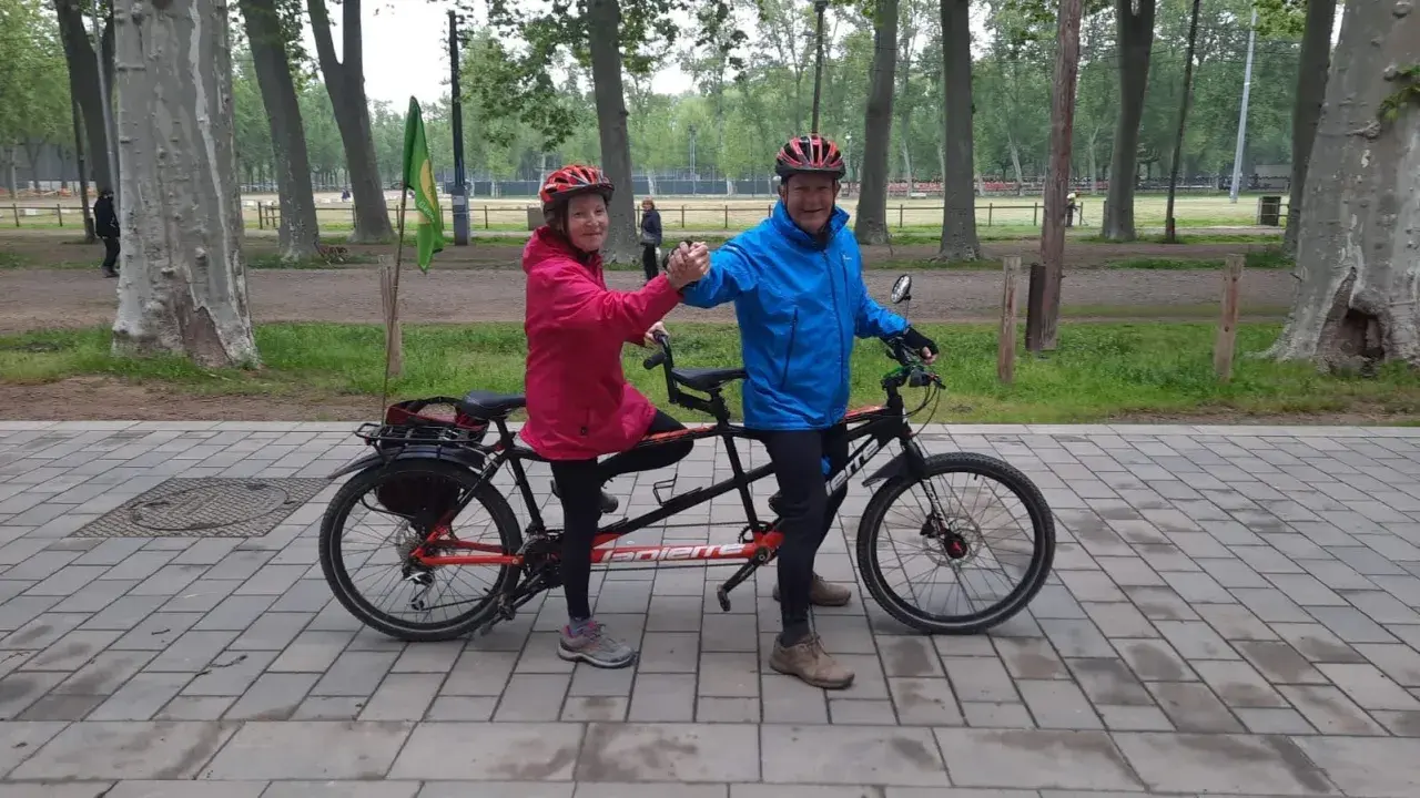 Pareja feliz en un eje tandem triaxial, disfrutando de un paseo en bicicleta por el parque.