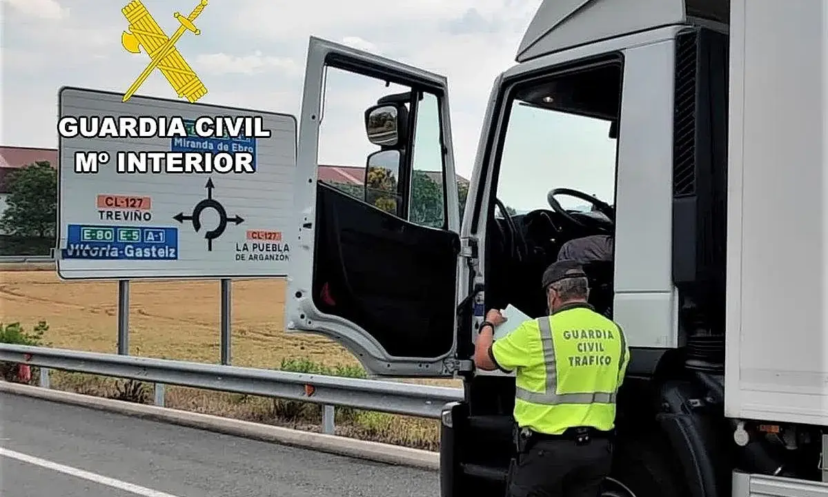 Agente de la Guardia Civil revisa documentación de un camión. Se puede conducir un camión sin tarjeta de transporte si se cumplen ciertos requisitos.