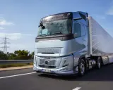 El nuevo Volvo FH Aero, un camión azul metálico, avanza por una carretera soleada, listo para transportar cargas con su diseño aerodinámico.