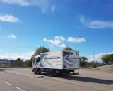 Camión de autoescuela Zarzaquemada, listo para obtener el carnet C+E. Cielo azul con nubes.