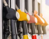 Mangueras de gasolinera en fila, listas para llenar el tanque y promover el ahorro de combustible.
