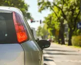 Vista trasera de un coche de autoescuela por dentro, con el piloto rojo encendido. El alumno se prepara para girar.