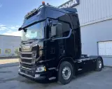 Camión Scania R590 negro brillante, listo para la carretera.