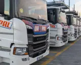 Fila de camiones Scania Super blancos, listos para la carretera.