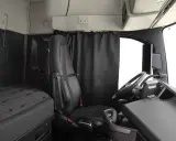 Interior de un camión Volvo FH XXL. Asiento del conductor, cama y volante.