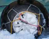 Neumático con cadenas de nieve instaladas, mostrando cómo se ponen las cadenas de nieve para circular en condiciones invernales.