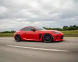 Un deportivo rojo, uno de los **vehículos ligeros** más ágiles, surca la carretera bajo un cielo nublado.