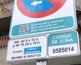 Señal de tráfico de carga y descarga con horarios y código de zona.