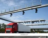 Camión rojo pasa por pórtico de peaje electrónico, similar a los de euroviñeta en Luxemburgo y Holanda.