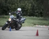 Persona con casco y equipación de moto practica maniobras en circuito con conos. Averigua el carnet de moto a1 precio.