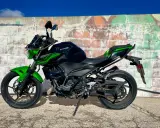 Kawasaki Ninja 400 negra y verde, lista para la aventura. Un carnet moto grande es lo que necesitas para domarla.