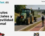 Un tractor, un vehículo especial, circula por carretera junto a un patinete eléctrico y señales de tráfico.