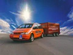 Coche naranja con remolque, listo para obtener el carnet B96.