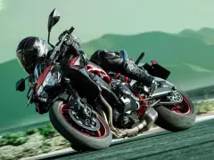 Motociclista con permiso A2 que puedo conducir, inclinado en curva con moto deportiva roja y negra.