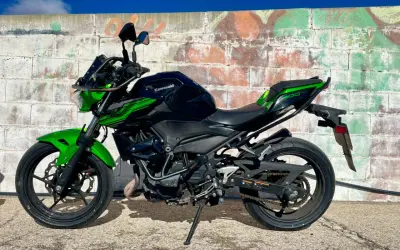 Kawasaki Ninja 400 negra y verde, lista para la aventura. Un carnet moto grande es lo que necesitas para domarla.