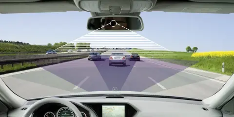 Vista desde el interior de un coche en autopista, mostrando cómo los **sistemas ADAS** detectan otros vehículos y el entorno.