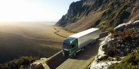 Camión Iveco S-Way 530 verde en carretera montañosa. Las opiniones sobre este modelo son muy positivas.