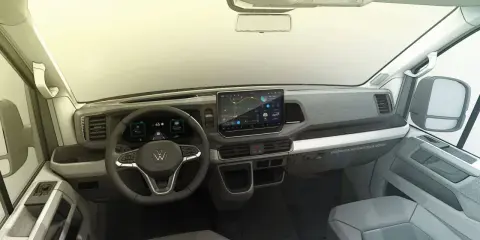 Interior de la Volkswagen Crafter, con pantalla táctil central, volante multifunción y diseño moderno.