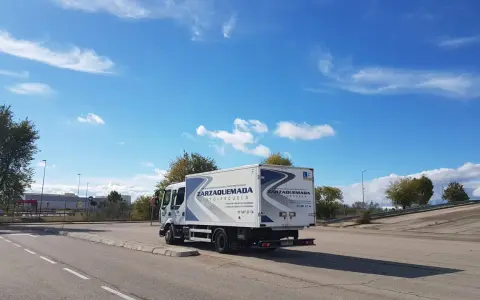 Camión de autoescuela Zarzaquemada, listo para obtener el carnet C+E. Cielo azul con nubes.