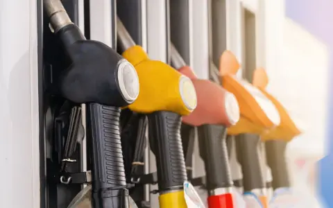 Mangueras de gasolinera en fila, listas para llenar el tanque y promover el ahorro de combustible.