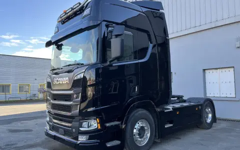 Camión Scania R590 negro brillante, listo para la carretera.