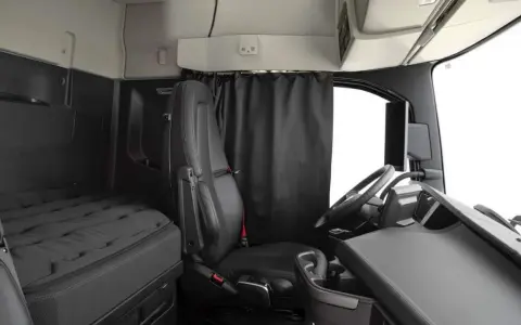 Interior de un camión Volvo FH XXL. Asiento del conductor, cama y volante.