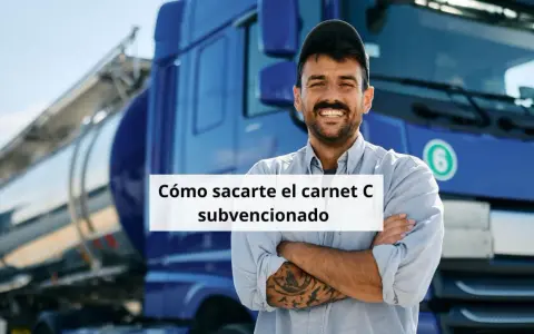 Hombre sonriente con tatuajes, frente a un camión cisterna azul. Aprende cómo obtener tu carnet de camión gratis para desempleados.