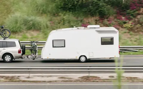 Vehículo todoterreno con remolque caravana y bicicletas, listo para viajar con el permiso de circulación b.