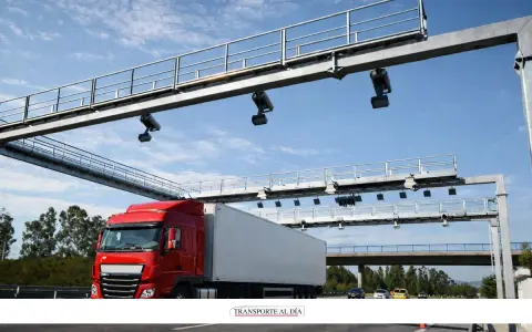 Camión rojo pasa por pórtico de peaje electrónico, similar a los de euroviñeta en Luxemburgo y Holanda.