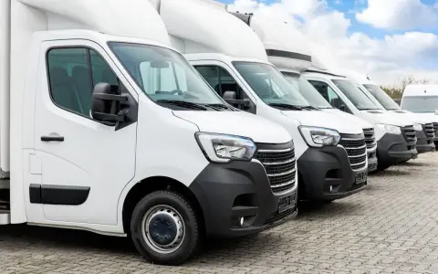 Fila de furgonetas blancas listas para la entrega. El modelo dgt n1 es el primero de la fila, con un diseño moderno y robusto.