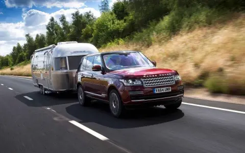 Range Rover rojo arrastra una caravana Airstream. Con el carnet B+E, puedes llevar este tipo de remolque.