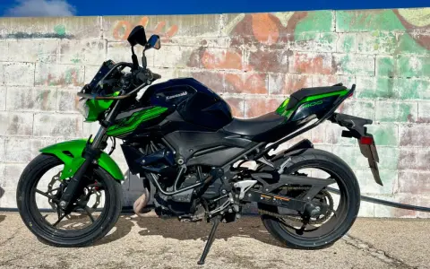 Kawasaki Ninja 400 negra y verde, lista para la aventura. Un carnet moto grande es lo que necesitas para domarla.
