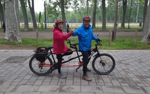 Pareja feliz en un eje tandem triaxial, disfrutando de un paseo en bicicleta por el parque.