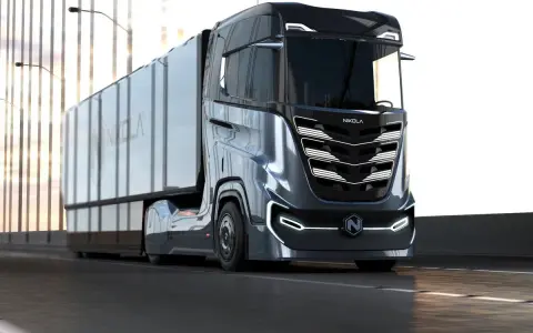 Camión Nikola Tre futurista en carretera, con su diseño aerodinámico y luces LED.
