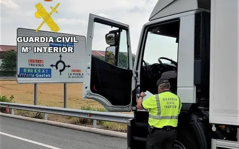 Agente de la Guardia Civil revisa documentación de un camión. Se puede conducir un camión sin tarjeta de transporte si se cumplen ciertos requisitos.