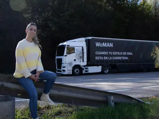 Mujer junto a un camión con el lema "WoMAN". ¿Esta permitido conducir un camión con el permiso B?