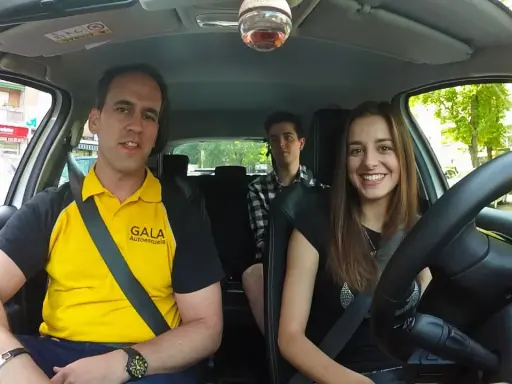 Instructor de autoescuela sonríe junto a dos alumnos en un coche. ¡Listos para el turismo y el aprendizaje!