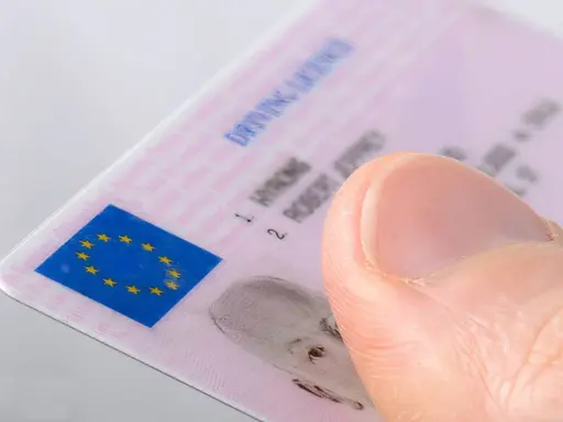 Pulgar sobre un carnet de conducir B2 con el logo de la UE.