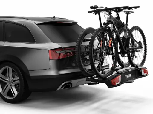 Portaequipajes trasero con dos bicicletas de montaña. Señalizar la carga que sobresale de un camión es crucial para la seguridad vial.